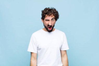 Genç çılgın sakallı adam şok olmuş, kızgın, sinirli ya da hayal kırıklığına uğramış, ağzı açık ve öfkeli görünüyordu.