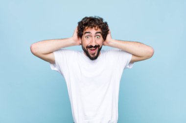 Genç çılgın sakallı adam mutlu, kaygısız, arkadaş canlısı ve rahat görünüyor. Hayattan ve başarıdan keyif alıyor ve yassı duvara karşı pozitif bir tutum sergiliyor.