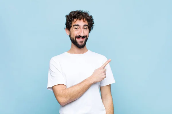 Joven Barbudo Loco Sonriendo Alegremente Sintiéndose Feliz Señalando Hacia Lado —  Fotos de Stock