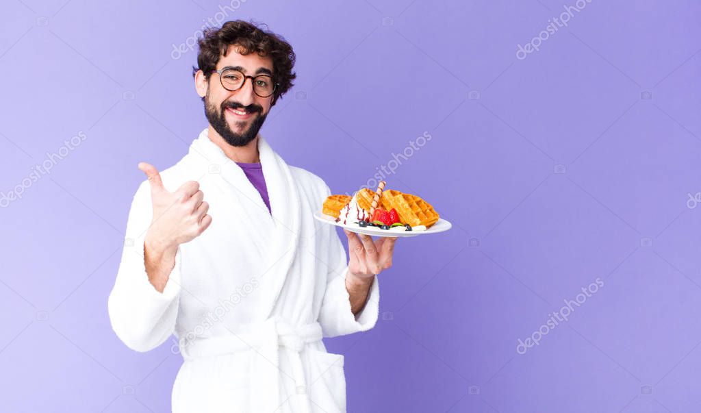 young crazy bearded man  wearing bathrobe and having waffles