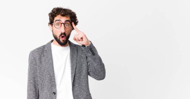 Genç çılgın işadamı şaşırmış, ağzı açık, şok olmuş, düz duvara karşı yeni bir düşünce, fikir ya da konsept keşfediyor.