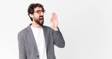 Genç çılgın işadamı sinirle bağırıyor kenardaki boşluğu kopyalamak için, ağızları düz duvara dayalı.