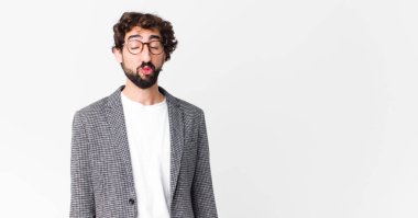 Genç çılgın iş adamı dudaklarını birbirine bastırıyor, tatlı, eğlenceli, mutlu, sevimli bir yüz ifadesiyle, düz duvara bir öpücük yolluyor.