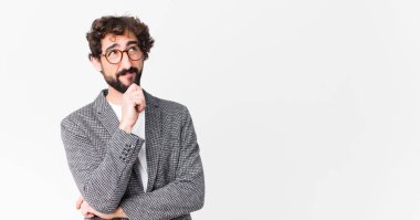 Genç çılgın iş adamı düşünceli, meraklı ya da hayal kuruyor, hayal kuruyor ve düz duvara uzayı kopyalamak istiyor.