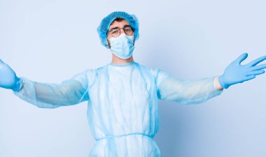 Genç adam neşeyle gülümsüyor sıcak, dostça, sevgi dolu bir kucak veriyor, mutlu ve sevimli hissediyor. Coronavirus konsepti