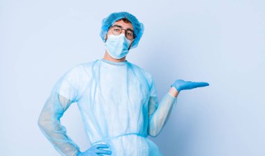 Genç adam gülümsüyor, kendinden emin, başarılı ve mutlu hissediyor, fotokopi alanında fikir ya da konsept gösteriyor. Coronavirus konsepti