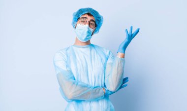 Genç adam gururla ve özgüvenle gülümsüyor, mutlu ve tatmin olmuş hissediyor ve fotokopi alanında bir konsept gösteriyor. Coronavirus konsepti