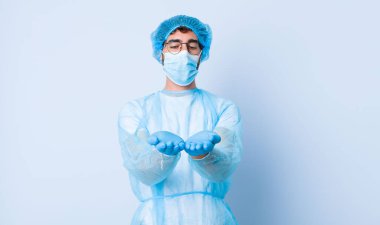 Genç adam mutlu bir şekilde gülümsüyor, kendine güvenen, pozitif bakışlı, bir nesne ya da konsept sunuyor ve gösteriyor. Coronavirus konsepti