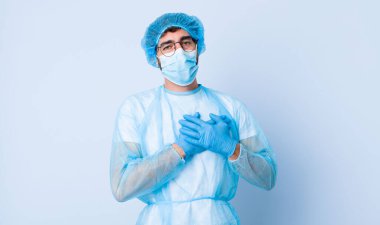 Genç adam romantik, mutlu ve aşık, neşeyle gülümseyen ve kalbe yakın el ele tutuşan. Coronavirus konsepti