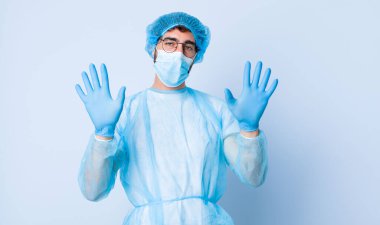 Genç adam gülümsüyor ve arkadaş canlısı görünüyor, onuncu ya da onuncu numarayı gösteriyor, eli önde, geriye doğru sayıyor. Coronavirus konsepti