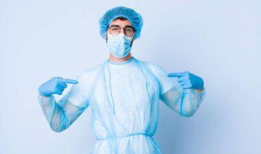 Genç adam iki eliyle göğsünü gösteren gururlu, pozitif ve sıradan birine benziyor. Coronavirus konsepti