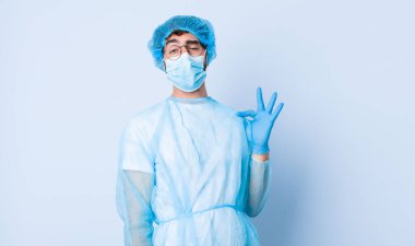 Genç adam kibirli, başarılı, pozitif ve gururlu görünüyor, kendini işaret ediyor. Coronavirus konsepti
