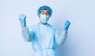Genç adam inanılmaz bir başarıyı kutluyor kazanan gibi, heyecanlı ve mutlu görünüyor. Coronavirus konsepti