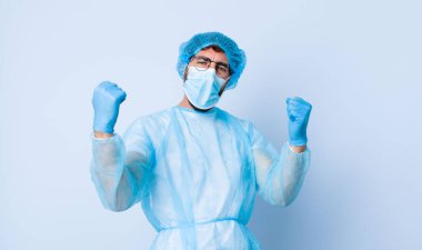 Genç adam mutlu, şaşkın ve gururlu, bağırıyor ve başarıyı büyük bir gülümsemeyle kutluyor. Coronavirus konsepti