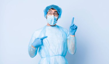 Genç adam gururlu ve şaşırmış hissediyor, kendine güvenen, kendini başarılı bir numara gibi hisseden. Coronavirus konsepti