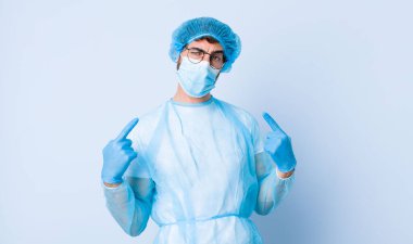 Kötü tavırlı genç bir adam gururlu ve agresif görünüyor, yukarı bakıyor ya da ellerle alay ediyor. Coronavirus konsepti