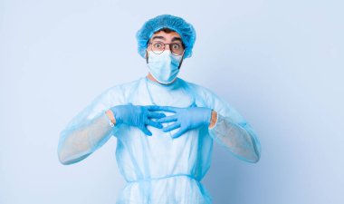 Genç adam mutlu görünüyor, şaşırmış, gururlu ve heyecanlı, kendini işaret ediyor. Coronavirus konsepti