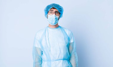 Genç adam şaşkın ve şaşkın görünüyor, gergin bir hareketle dudağını ısırıyor, sorunun cevabını bilmiyor. Coronavirus konsepti