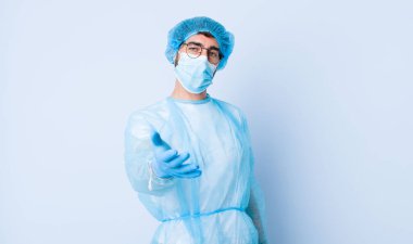 Genç adam gülümsüyor, mutlu görünüyor, kendinden emin ve arkadaş canlısı, bir anlaşma için el sıkışmayı teklif ediyor, işbirliği yapıyor. Coronavirus konsepti