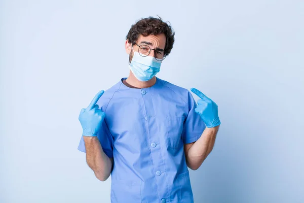 young man with a bad attitude looking proud and aggressive, pointing upwards or making fun sign with hands. coronavirus concept