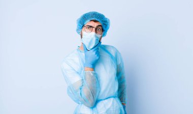 Ağzı ve gözleri sonuna kadar açık ve eli çenesinde olan genç bir adam, hoş olmayan bir şok geçiriyor, ne ya da vay canına diyor. Coronavirus konsepti