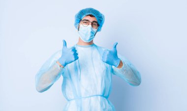 Genç adam mutlu, pozitif, kendine güvenen ve başarılı bir şekilde gülümsüyor. Coronavirus konsepti