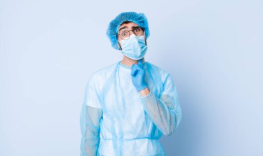 Yanak tutan ve ağrılı diş ağrısı çeken genç bir adam, hasta, sefil ve mutsuz hisseden, dişçi arayan. Coronavirus konsepti