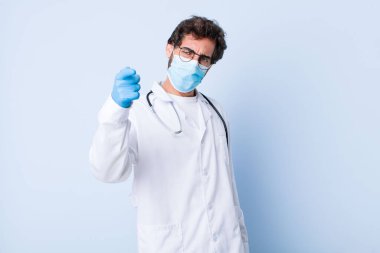 Öfkeli agresif bir ifadeyle kameraya bakan genç bir adam öfkeli, çılgın bir patron gibi görünüyor. Coronavirus konsepti