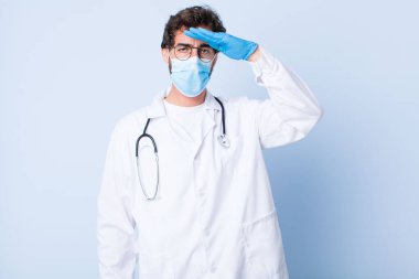 Genç adam, saygı göstererek, onur ve vatanseverlik adına askeri bir selamlama ile kamerayı selamlıyor. Coronavirus konsepti