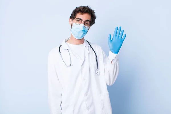 Young Man Smiling Happily Cheerfully Waving Hand Welcoming Greeting You — Stock Photo, Image