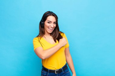 Genç, güzel bir kadın mutlu, pozitif ve başarılı hissediyor, bir meydan okumayla karşılaştığında motive oluyor veya iyi sonuçları kulaklık ve mikrofonla kutluyor.