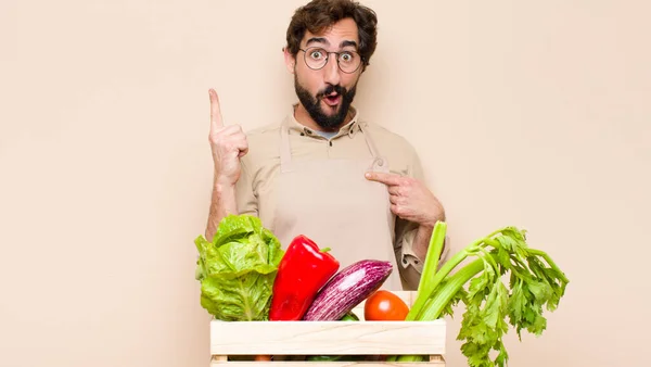 green grocery man feeling proud and surprised, pointing to self confidently, feeling like successful number one