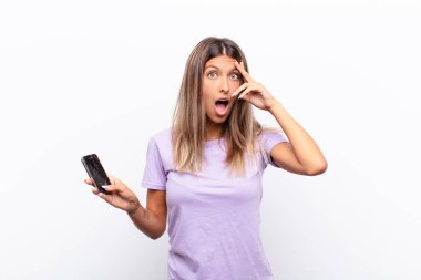 Genç ve güzel bir kadın mutlu görünüyor, şaşırmış ve şaşırmış, gülümsüyor ve inanılmaz ve inanılmaz bir haberi fark ediyor.