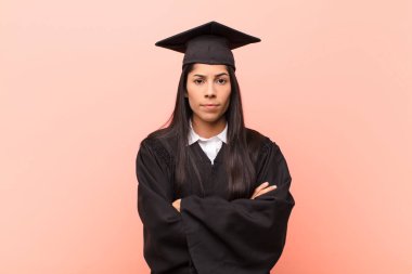 Genç Latin kız öğrenci hayal kırıklığına uğramış ve hayal kırıklığına uğramış, ciddi görünüyor, kızgın ve kollarını kavuşturmuş.