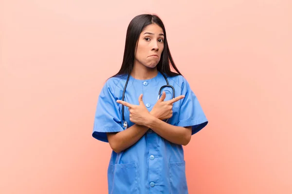 Junge Lateinamerikanische Krankenschwester Schaut Verwirrt Und Verwirrt Unsicher Und Zeigt — Stockfoto