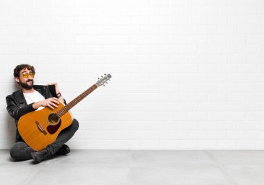 Genç müzisyen kibirli, başarılı, pozitif ve gururlu görünüyor. Kendini gitar, rock 'n roll konseptiyle gösteriyor.