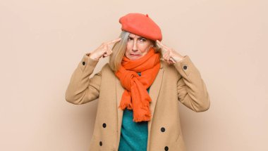 Yaşlı ya da orta yaşlı güzel bir kadın konsantre olmuş ve bir fikir üzerinde kafa yoruyor, bir soruna ya da soruna çözüm bulmayı hayal ediyor.