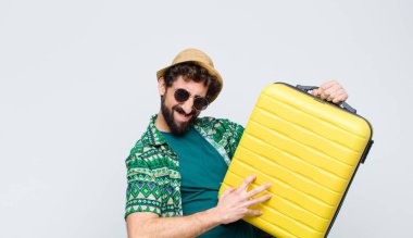 Beyaz duvara karşı takım elbiseli genç bir turist. seyahat kavramı