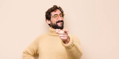 Genç, havalı bir adam kameraya bakıyor. Tatmin olmuş, kendine güvenen, dost canlısı bir gülümsemeyle. Seni düz duvara karşı seçiyor.