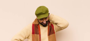 Genç, havalı sakallı adam neşeli ve kendinden emin bir şekilde gülüyor, mutlu, dostane bir gülümsemeyle.