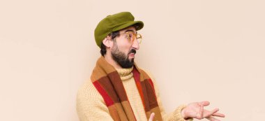 Genç havalı sakallı adam bilgisiz ve kafası karışık, hangi seçeneği seçeceğinden emin değil, merak ediyor.