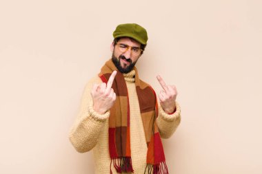 Genç havalı sakallı adam kışkırtıcı, agresif ve müstehcen hissediyor. İsyankar bir tavırla orta parmağını hareket ettiriyor.