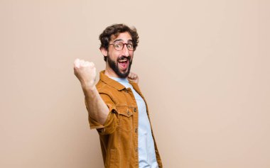 Genç, havalı ve çılgın adam yassı duvara yaslanmış.