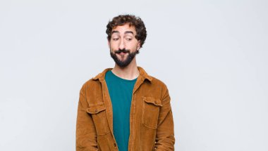 Genç yakışıklı adam merak ediyor, mutlu düşünceler ve fikirler düşünüyor, hayal kuruyor, düz duvara uzayı kopyalamaya çalışıyor.