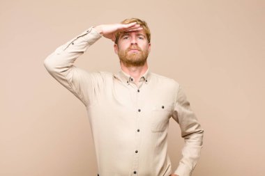 Genç sarışın adam kameraya askeri bir selamlama ile selam veriyor onur ve vatanseverlik göstergesi olarak, düz duvara karşı saygı gösteriyor.
