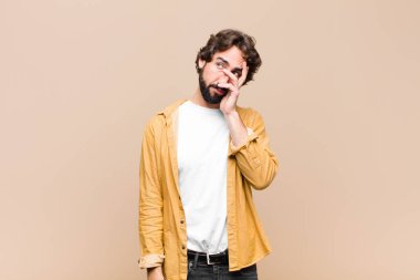 Sıkıcı, sıkıcı, sıkıcı ve can sıkıcı bir görevin ardından sıkılmış, hayal kırıklığına uğramış ve uykulu hisseden genç, havalı bir adam.