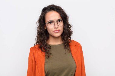 Genç, güzel bir kadın kendini şaşkın ve kuşkulu hissediyor, merak ediyor ya da beyaz duvara karşı karar vermeye çalışıyor.