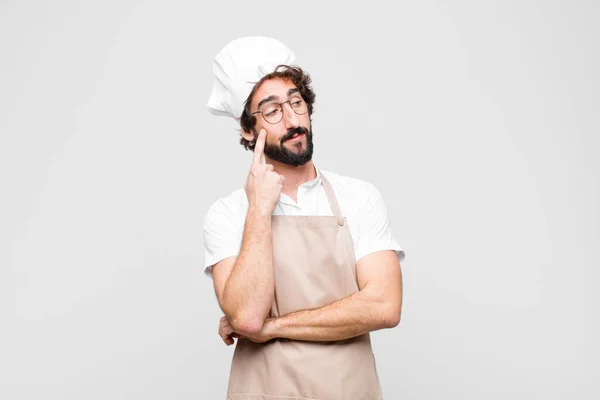 Junger Verrückter Koch Mit Konzentriertem Blick Fragend Mit Zweifelndem Gesichtsausdruck — Stockfoto
