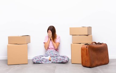 Kızıl saçlı güzel bir kadın üzgün, hayal kırıklığına uğramış, gergin ve depresif, iki eliyle yüzünü kapatmış, yeni bir evde ağlıyor.