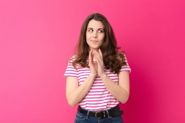 Genç, güzel bir kadın gururlu, yaramaz ve kibirli hissederken şeytani bir plan yaparken ya da pembe duvara karşı bir numara düşünürken